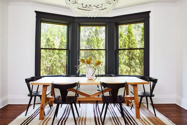 Silicon Valley property real estate agents Wooden table and black chairs in front of a window with black frame.